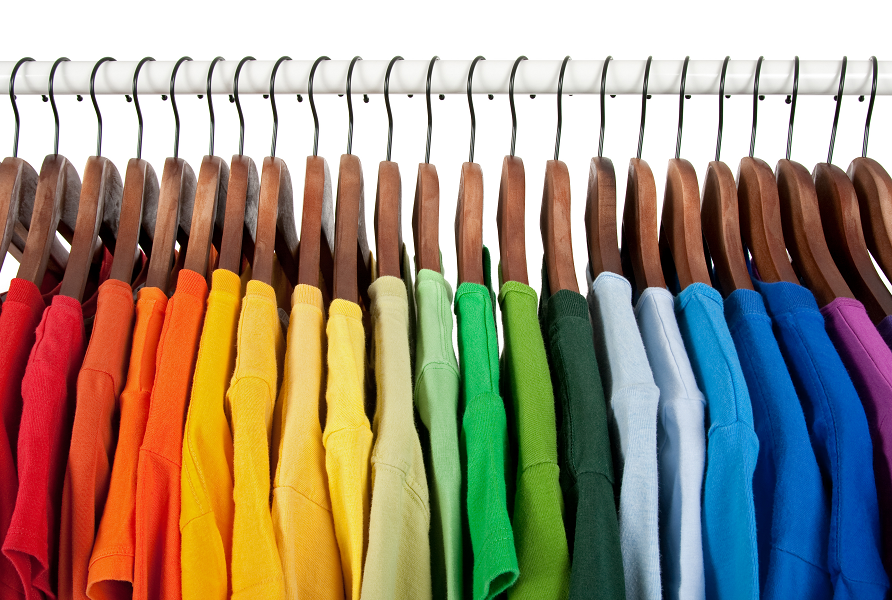 A rail of T-shirts organised in the order of the colours of the rainbow.